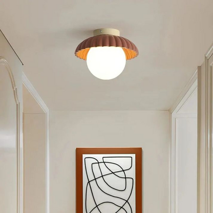 Lampa sufitowa z mlecznym kloszem zapewniająca ciepłe oświetlenie w holu